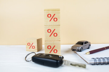 car with keys and documents, wooden cubes with a percentage sign.