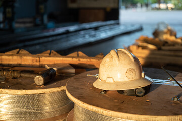 A white safety working hardhat or helmet in orange sun lighting which is placed on the material...