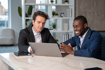 Smiling African American businessman talking to colleague explaining project