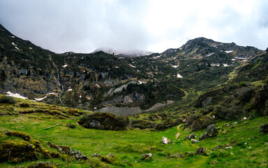 Fototapeta na wymiar Hiking trail in the pastures nears Ayes Lake in the French Pyrenees mountains range on a cloudy day