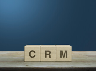 CRM letter on wood block cubes on wooden table over light blue wall, Customer Relationship Management concept