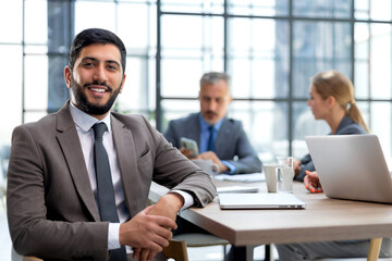Businessman with colleagues in the background in office.