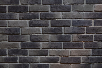 A section of rows of gray bricks on the interior wall of a building.