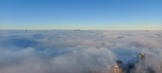 Fototapeta premium above the clouds, skyscrapers under construction, vancouver weather