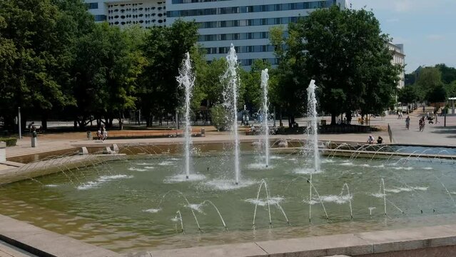 A fountain in the city center near the old water tower on a summer sunny day.