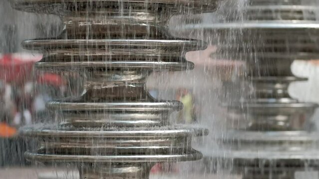 Close-up of a detail of the modern new waterfall fountain in Germany. The water flows on stainless steel metal disks.
