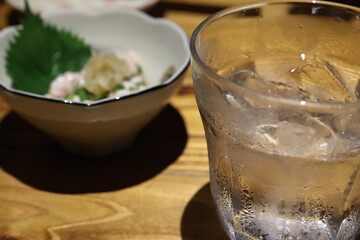 焼酎のグラスとおつまみが置いてるテーブル