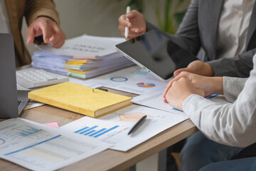 Marketing, Finance, Accounting, Planning, Team of business use calculators and graph analysis computer laptop tablets to plan marketing strategies and make profitable investments for the company.