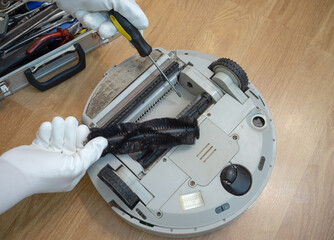 Replacement of components in the robot vacuum cleaner. Removing the brush and dust bag in the...