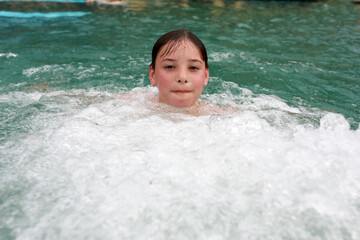 Boy doing hydromassage of his chest in thermal pool