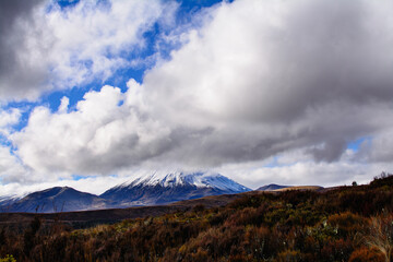 Snow blanketed volcanic cone of Mount Ngauruhoe covered by low clouds. Desolated high land field in Central Plateau of New Zealand. Tongariro National Park, North Island