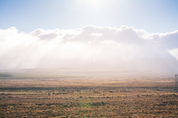 Sun shines over low clouds above vast and empty land along Volcanic Loop Hwy and Desert Road. Central Plateau, New Zealand
