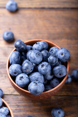 Freshly picked blueberries in  bowl. Bilberry on wooden Background. Blueberry antioxidant. Concept for healthy eating and nutrition