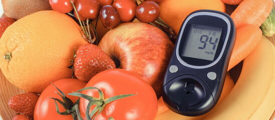 Glucometer with result of sugar level with fruits and vegetables. Healthy eating during diabetes