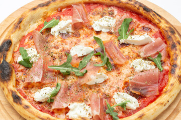 Delicious Italian pizza with ham, cheese, arugula and tomatoes.
