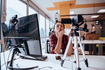A young woman using a camera to present her business with online clients 