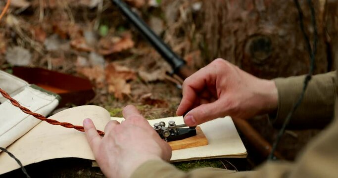 Russian Soviet Infantry Red Army Soldier In World War II using Russian Soviet Portable Radio Transceiver In Trench Entrenchment In Spring Autumn Forest. 4K. Headphones And Telegraph Key. Close Up