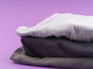 Folded clothes on a uniform background. Space for text