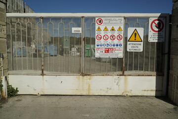 Ostia, Rome, Italy - November 10, 2022, detail of the access gate to the Department of Engineering of Technologies for the Sea, Roma Tre University, with signs for work in progress.	