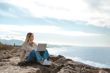 Remote work.Girl freelancer works remotely on the sea shore. workation, remote work,WFVH,Van Life vibes work from vacation home,work travel,remotely work.Travelling.Work from vacation remotely