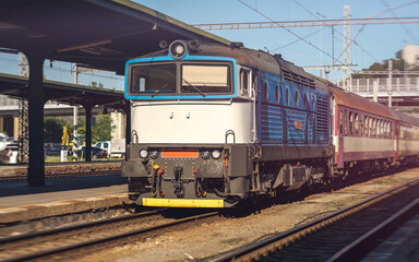 Obraz premium An Older Type Passenger Train Arriving at a Station of Industrial Construction, European Train Connections