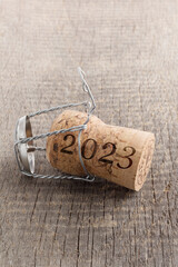 Champagne cork with number 2023 on wooden background