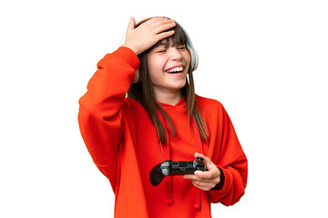 Little caucasian girl playing with a video game controller over isolated background smiling a lot © luismolinero
