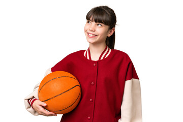 Little caucasian girl playing basketball over isolated background thinking an idea while looking up