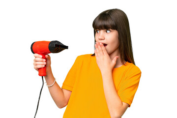 Little Caucasian girl holding a hairdryer over isolated background with surprise and shocked facial expression