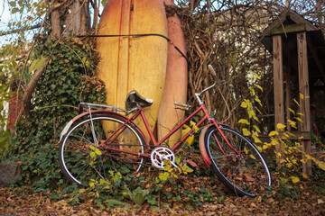 Fototapeta na wymiar A still life of a vintage bicycle and paddle boards during an autumn month