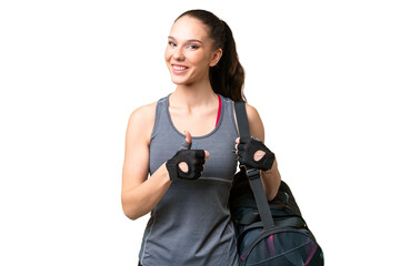 Young sport woman with sport bag over isolated background giving a thumbs up gesture