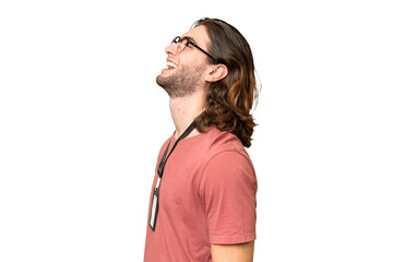 Young handsome man with ID card over isolated background laughing in lateral position