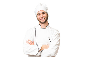 Young handsome chef man over isolated background keeping the arms crossed in frontal position