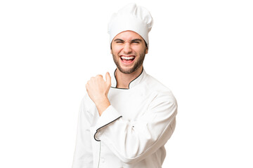 Young handsome chef man over isolated background celebrating a victory