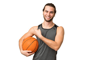 Fototapeta premium Young handsome man isolated on green chroma background playing basketball and pointing to the lateral