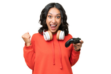 Young Argentinian woman playing with a video game controller over isolated background celebrating a victory in winner position