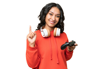 Young Argentinian woman playing with a video game controller over isolated background showing and...
