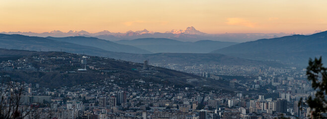 Obraz premium panoramic scenic aerial view of Tbilisi at dusk with Mount Kazbek on the horizon
