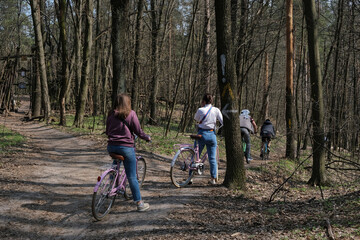 Naklejka premium Cyclists riding in a Spring forest at Holosiivskyi National Nature Park, Kyiv, Ukraine