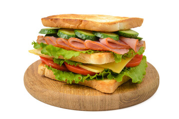 Homemade sandwich with ham, cheese, tomato and cucumber on wooden plate