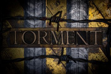 Torment text with barbed wire on grunge textured copper and gold background