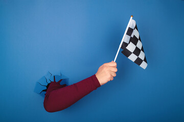 hand holding checkered flag over blue background