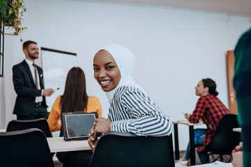 African American Muslim woman listens to a lecture aimed at business training