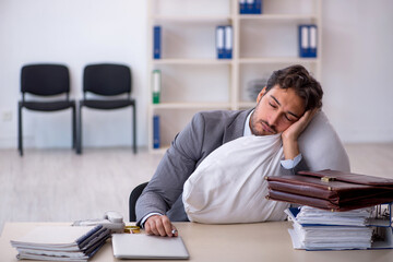 Young male employee in oversleeping concept