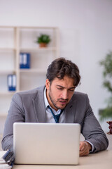 Young male employee in oversleeping concept