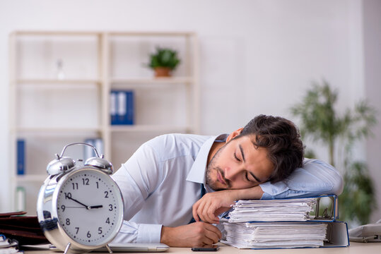 Young male employee in oversleeping concept