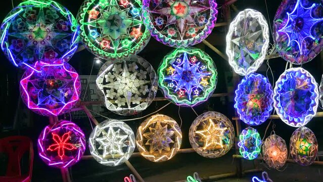 Parols for sale at a stand at nighttime. A Filipino ornamental lantern displayed during the Christmas season.