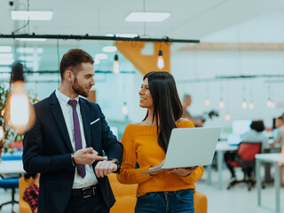 The boss of the company talking to his employee while she showing him the final report on the laptop