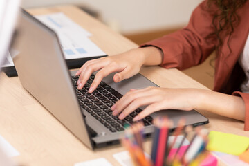Close up hand of business woman typing on keyboard working with computer laptop. Hands of woman chatting or writing article on work table at home. Female typing to communication on computer