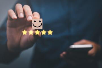 customer services best excellent business rating experience. Satisfaction survey concept. Hand of a businessman chooses a smile face on wood block cube. 5 Star Satisfaction.